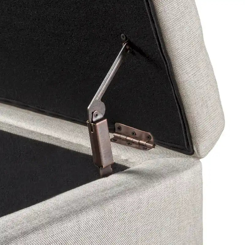 Banc de rangement ottoman Nancy, 130 cm, tissu beige, bordure cloutée en laiton